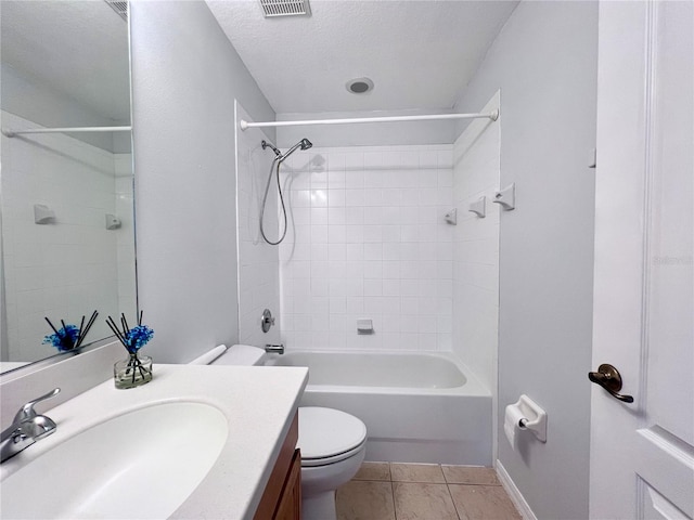 full bathroom featuring tiled shower / bath, vanity, a textured ceiling, toilet, and tile patterned floors