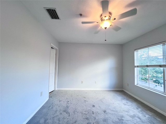 empty room featuring ceiling fan and carpet