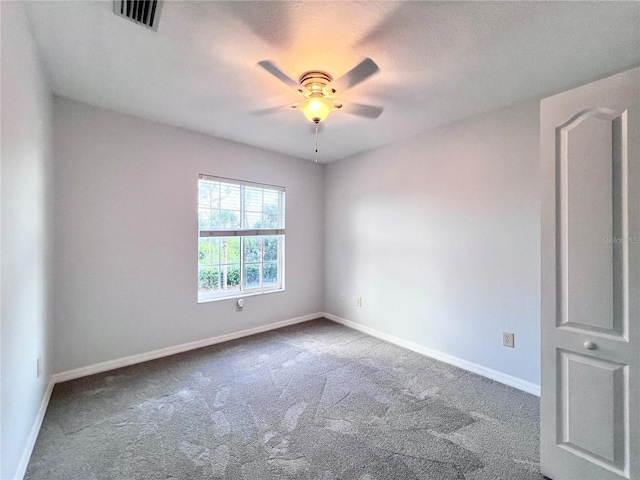 spare room with ceiling fan and carpet