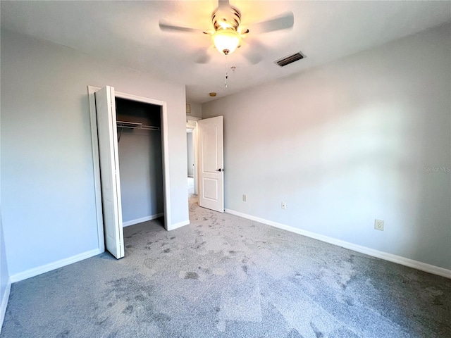 unfurnished bedroom featuring ceiling fan, a closet, and carpet