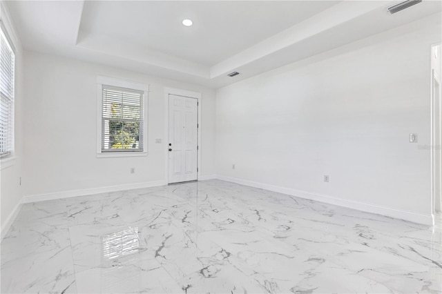 spare room with a tray ceiling