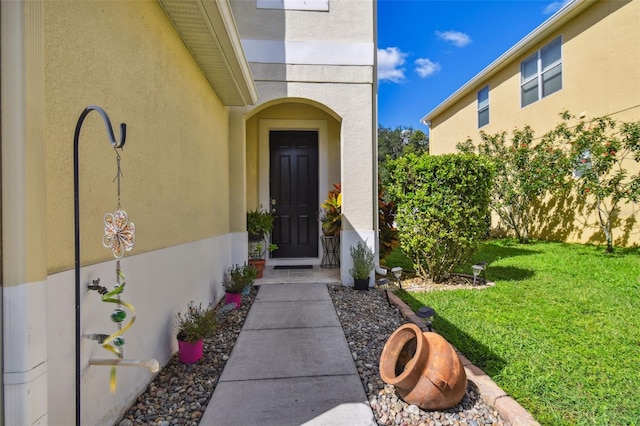 property entrance featuring a lawn