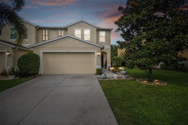 view of front facade with a garage and a yard