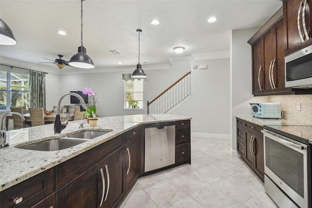 kitchen with light stone countertops, appliances with stainless steel finishes, a healthy amount of sunlight, and sink