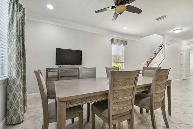 dining room with crown molding, light tile patterned floors, and ceiling fan