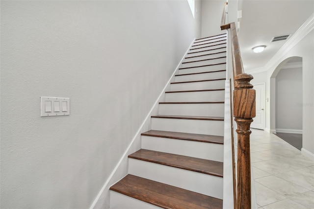 stairs featuring crown molding and tile patterned flooring