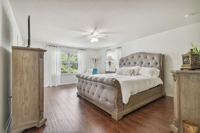 bedroom with a textured ceiling, ceiling fan, and dark hardwood / wood-style flooring