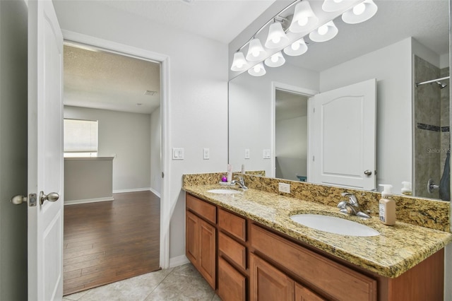 bathroom with vanity, hardwood / wood-style flooring, a textured ceiling, and a shower with door