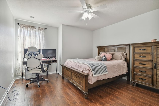 bedroom with ceiling fan, a textured ceiling, and dark hardwood / wood-style floors