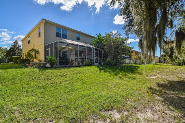 back of property featuring a lawn and a lanai