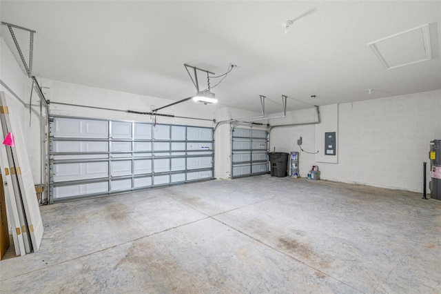 garage featuring electric water heater, electric panel, and a garage door opener