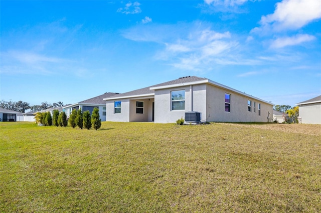 rear view of property with a lawn and central AC