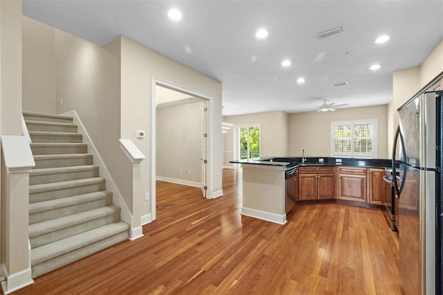 kitchen featuring sink, ceiling fan, light wood-type flooring, appliances with stainless steel finishes, and kitchen peninsula