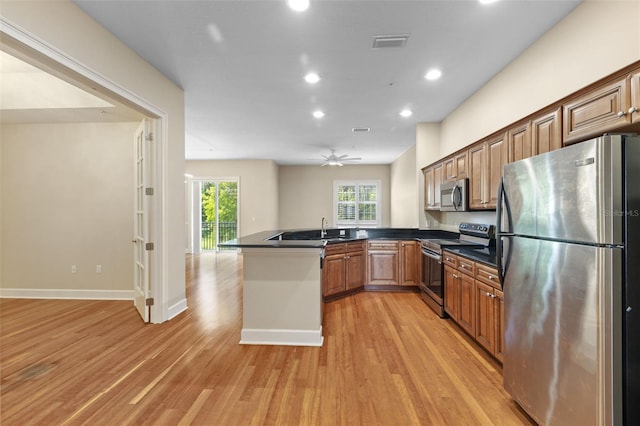 kitchen with ceiling fan, light hardwood / wood-style floors, kitchen peninsula, and appliances with stainless steel finishes