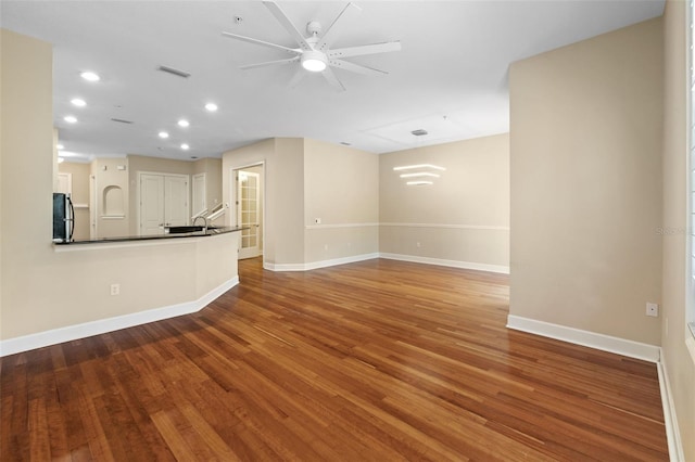 unfurnished living room with ceiling fan and wood-type flooring