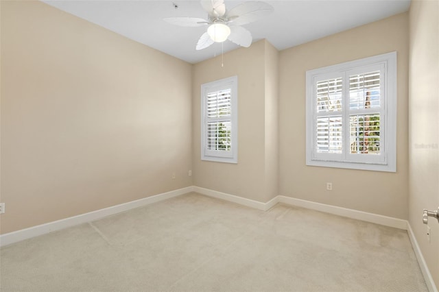 empty room featuring ceiling fan and light colored carpet