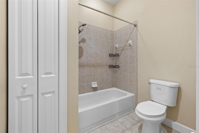 bathroom featuring tile patterned floors, tiled shower / bath combo, and toilet