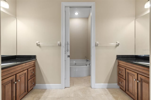 bathroom with a tub to relax in, tile patterned flooring, and vanity