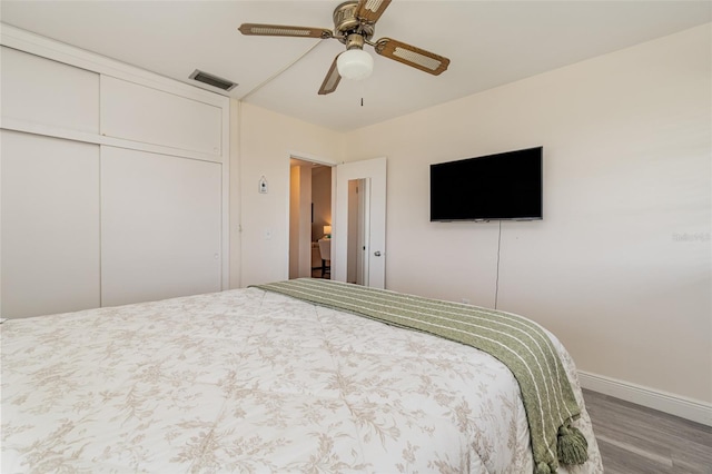 bedroom with hardwood / wood-style floors, ceiling fan, and a closet