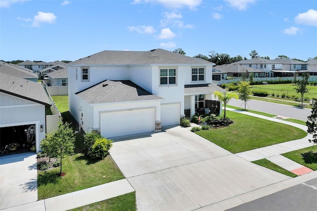 view of property featuring a garage and a front lawn