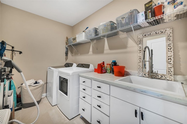 clothes washing area featuring cabinets, light tile patterned flooring, washer and clothes dryer, and sink