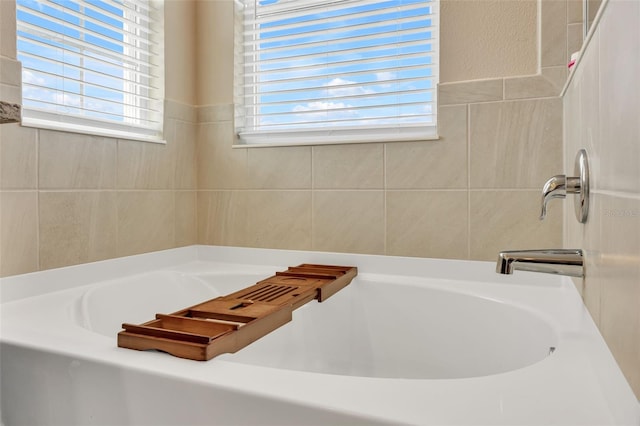 bathroom featuring a tub to relax in and plenty of natural light