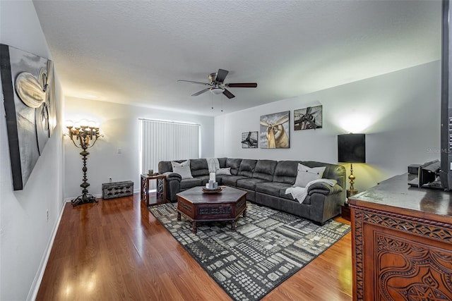 living room featuring ceiling fan, hardwood / wood-style floors, and a textured ceiling