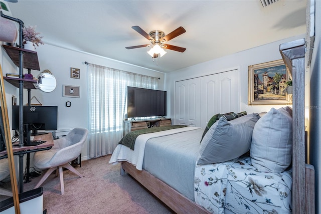 carpeted bedroom with ceiling fan and a closet