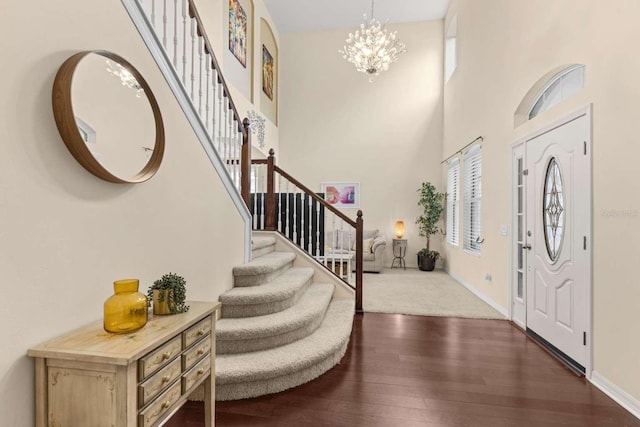 foyer entrance with a high ceiling, a chandelier, and dark hardwood / wood-style flooring