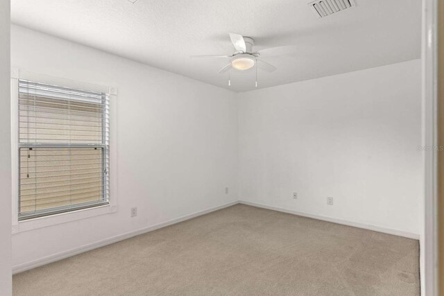 empty room featuring light carpet and ceiling fan