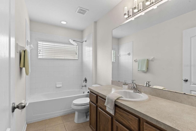 full bathroom with vanity, tiled shower / bath combo, toilet, and tile patterned floors