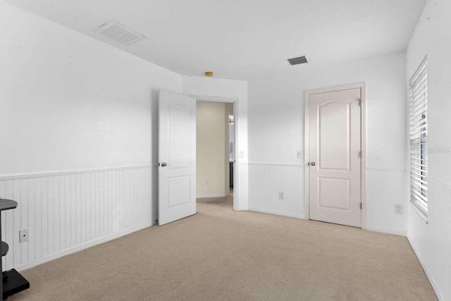 unfurnished bedroom featuring light carpet