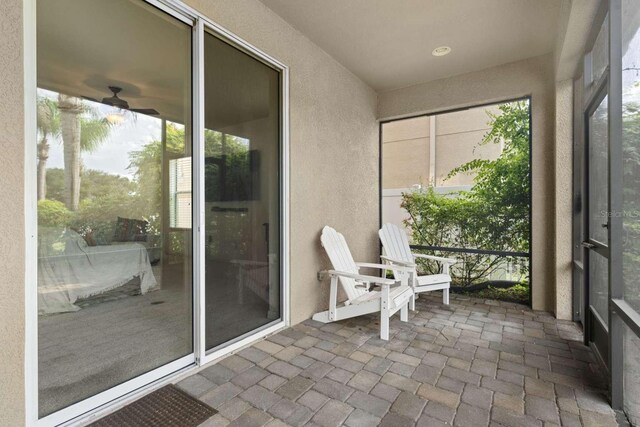 unfurnished sunroom featuring ceiling fan