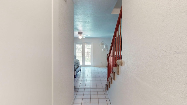 hallway featuring a textured ceiling and light tile patterned floors