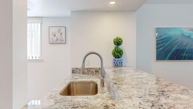 kitchen featuring sink and light stone counters