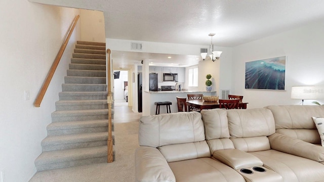 carpeted living room with a chandelier and a textured ceiling