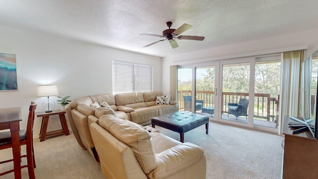 carpeted living room featuring ceiling fan and a textured ceiling