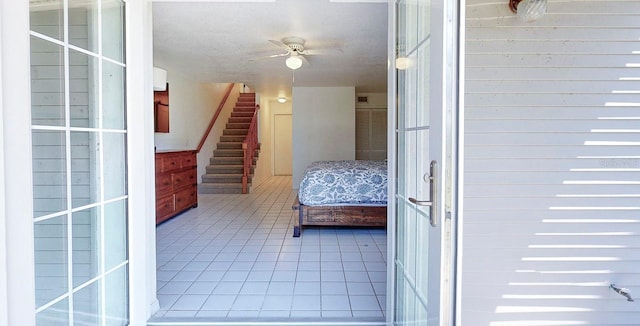 unfurnished bedroom featuring ceiling fan, a textured ceiling, and light tile patterned floors