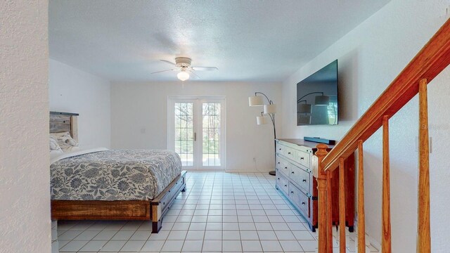 tiled bedroom featuring a textured ceiling, ceiling fan, and french doors