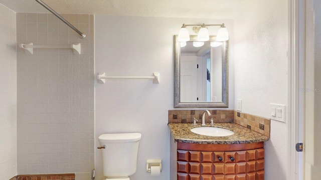 bathroom featuring a tile shower, vanity, toilet, and a textured ceiling