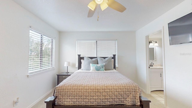 bedroom featuring light carpet, ensuite bath, ceiling fan, and sink