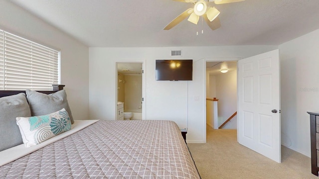 bedroom featuring light carpet, connected bathroom, and ceiling fan