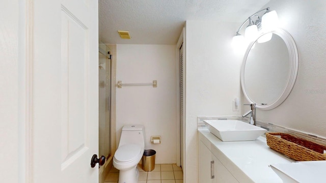 bathroom with vanity, walk in shower, a textured ceiling, tile patterned flooring, and toilet