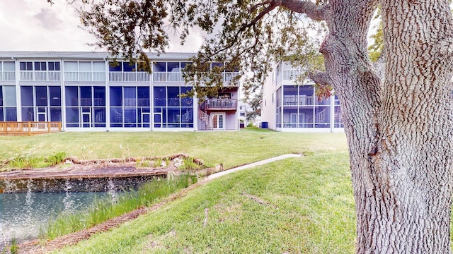 rear view of property with a lawn and a balcony