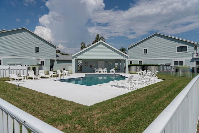 view of pool with a lawn and a patio