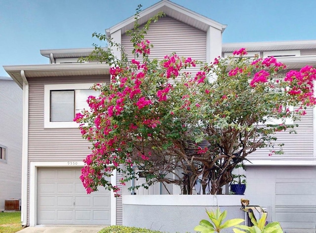 view of front of property featuring a garage and central air condition unit