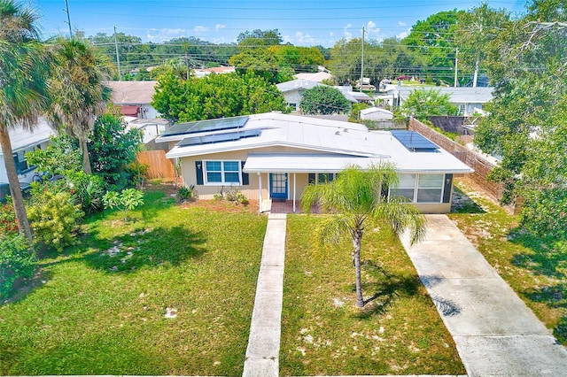 view of front of home featuring a front lawn, solar panels, and covered porch