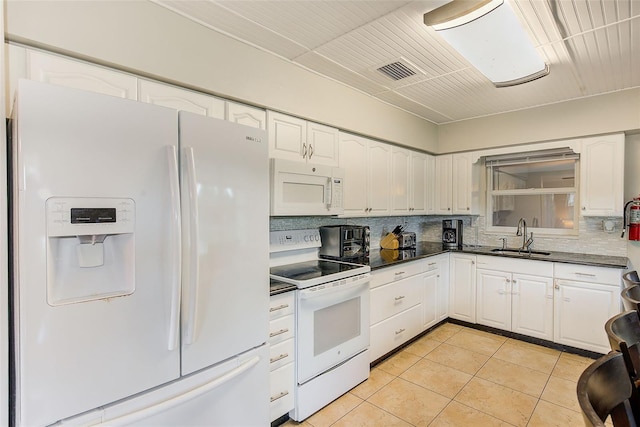 kitchen featuring white appliances, white cabinetry, sink, and light tile patterned floors