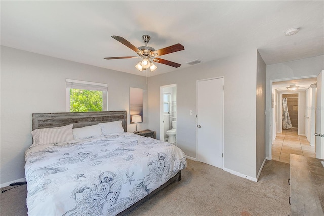 bedroom with ensuite bath, ceiling fan, and light colored carpet