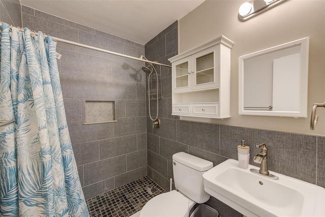 bathroom featuring tile walls, toilet, a shower with shower curtain, and sink